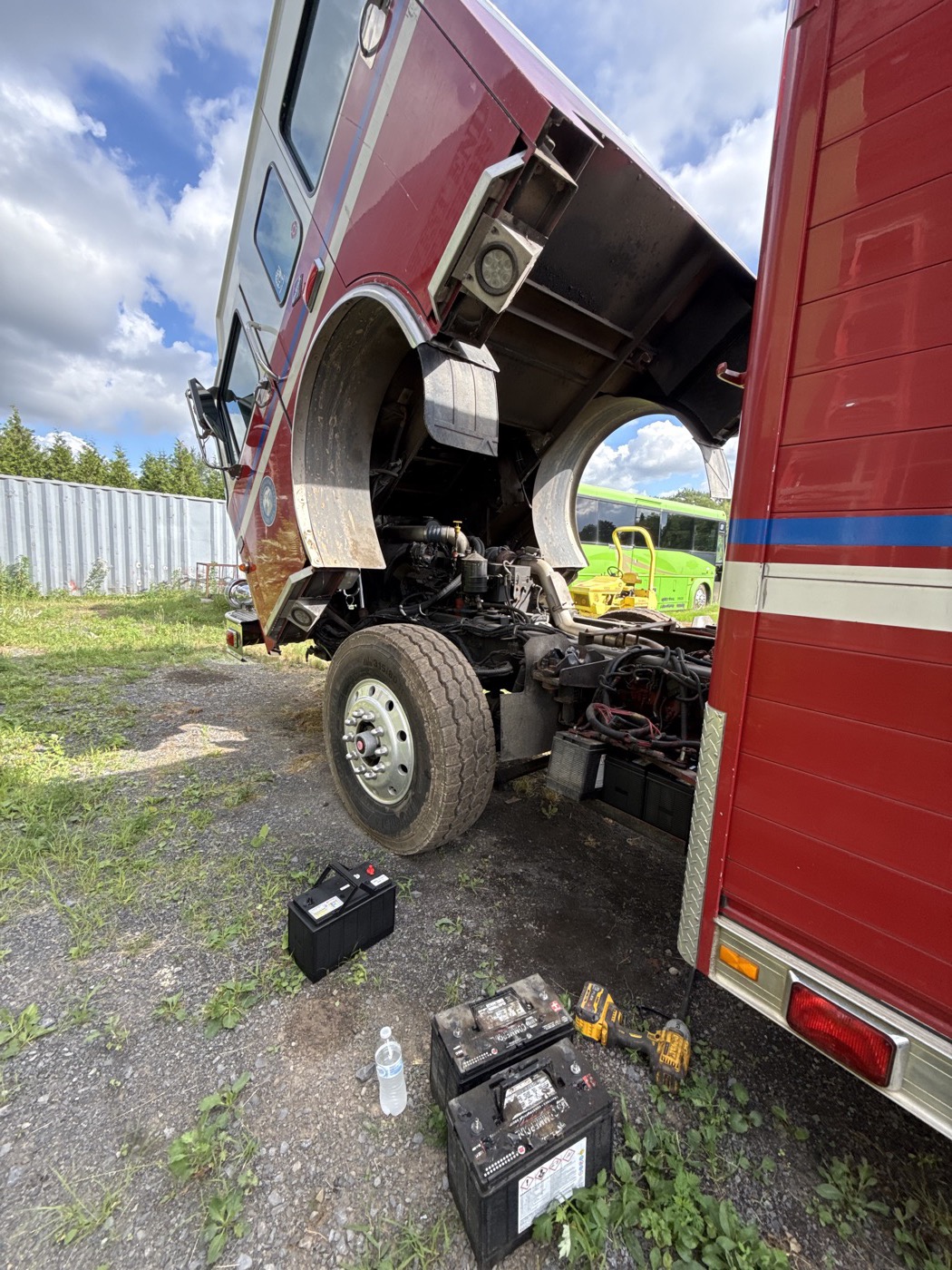 Fire apparatus cab raised during annual PM inspection with batteries and chassis access visible