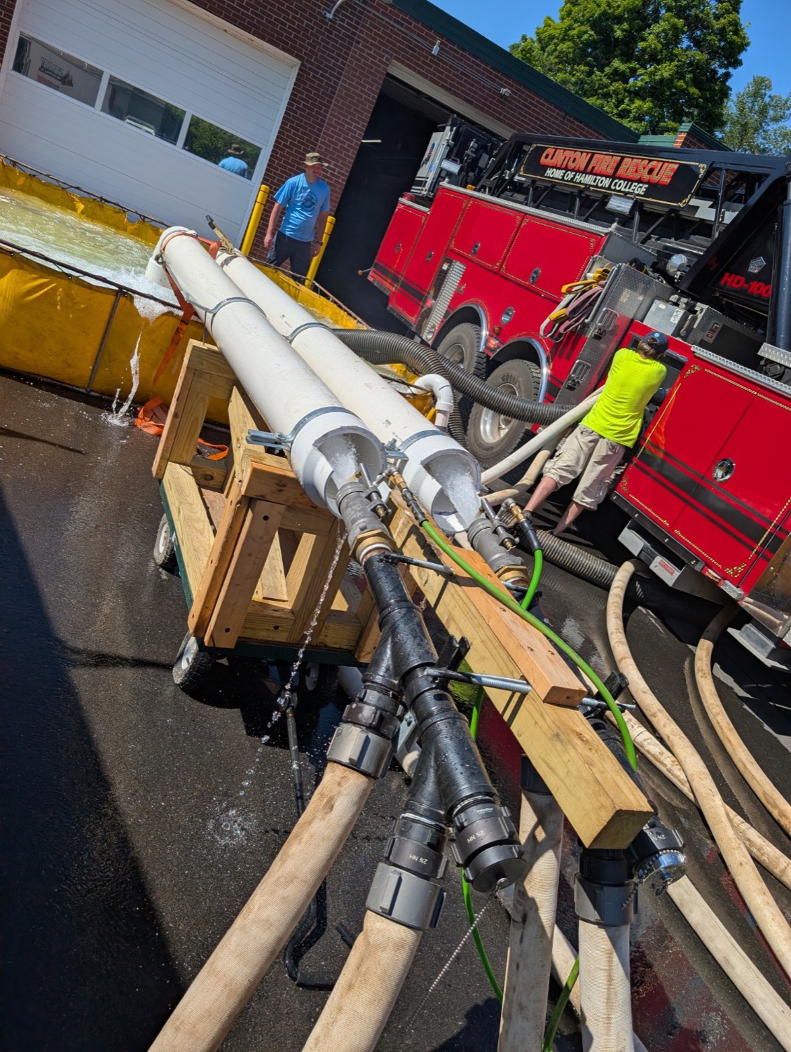 Pump test flow manifold and nozzles flowing water during an on-site fire apparatus pump test