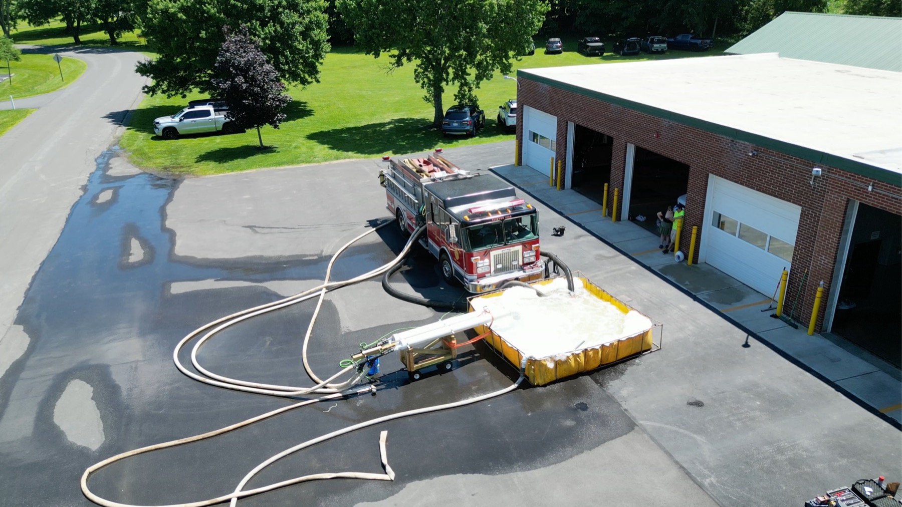 Fire engine connected to a portable tank during an on-site pump performance test at a fire station